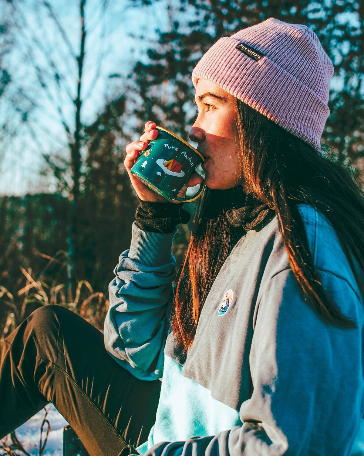 Blue Wave Crew Sweatshirt – kvinne drikker av emaljekrus iført genseren i kveldssol