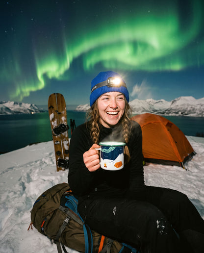Aurora Enamel Mug – smilende kvinne med kruset ved teltet under nordlyset