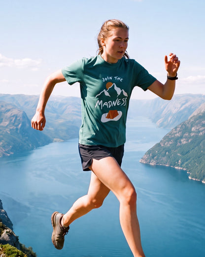 Join the Madness Teal Tee – kvinne i fjelløp langs en egg over fjorden