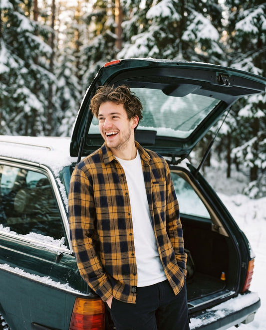 Voss Flannel Shirt Cloudberry – smilende mann ved en stasjonsvogn i snødekt skog