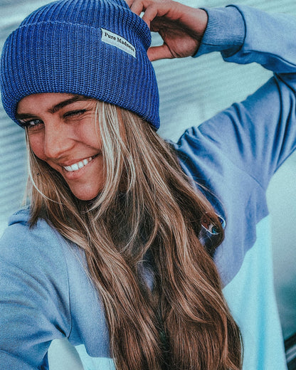 Blue Captain Merino Beanie – kvinne med den blå lua som blunker til kamera