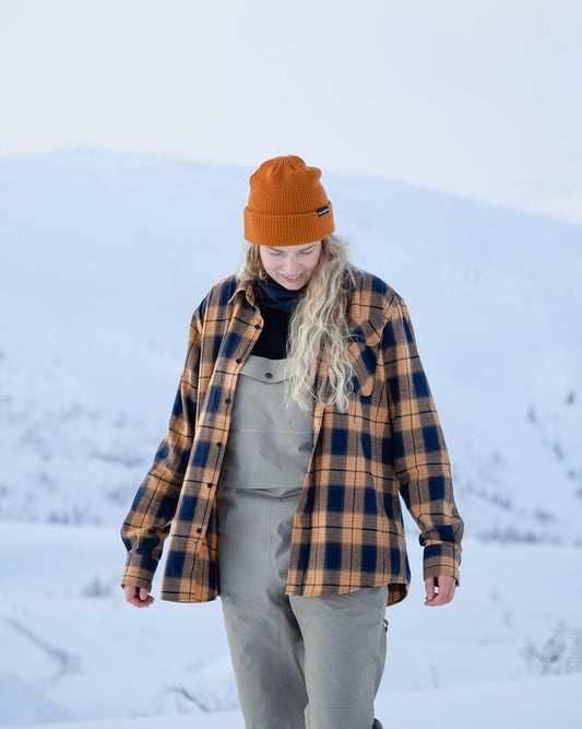Voss Flannel Shirt Cloudberry – kvinne i åpen flanellskjorte over bib-bukse i snøen